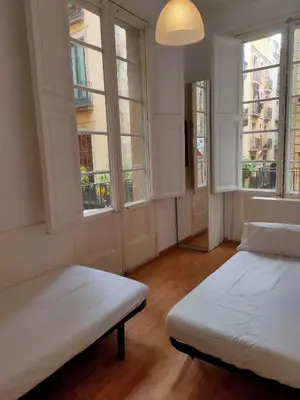 a room with two beds and two windows at Esparteria 1 in Barcelona