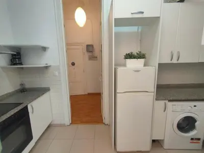 a kitchen with a white refrigerator and a washing machine at Esparteria 1 in Barcelona