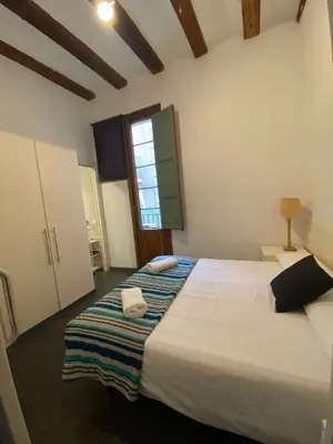 a bedroom with a large white bed with a window at Esparteria 2 in Barcelona