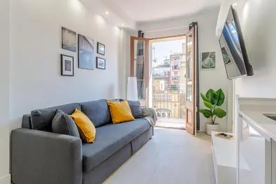 a living room with a blue couch with yellow pillows at 236 - AB Poble Sec Montjuic in Barcelona