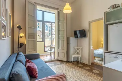 a living room with a blue couch and a television at AB Bailen Apartments in Barcelona