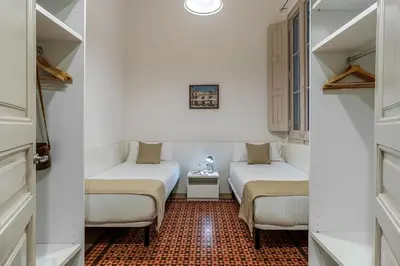 two beds in a room with white walls at AB Bailen Apartments in Barcelona