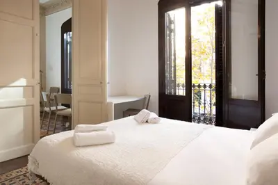 a bedroom with a white bed with two towels on it at AB Bailen Apartments in Barcelona