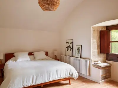 a bedroom with a white bed and a window at Les Canes in Aiguafreda