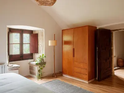 a bedroom with a wooden cabinet and a bed at Les Canes in Aiguafreda