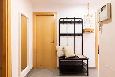 a room with a door and a bench with a pillow at AB Plaça de Sants in Barcelona