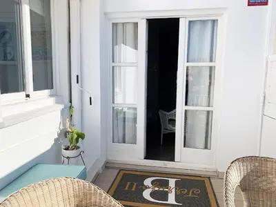 a front porch with a door and chairs and a rug at Sitges Spaces Bonaire Penthouse in Sitges