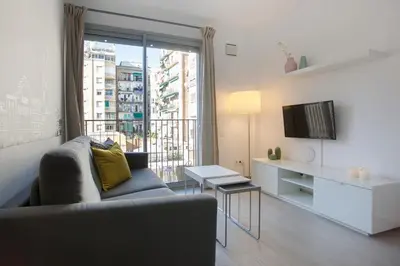 a living room with a couch and a large window at BBarcelona Gaudí Flats in Barcelona