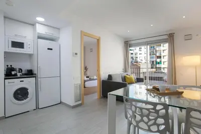 a kitchen and living room with a table and a dining room at BBarcelona Gaudí Flats in Barcelona