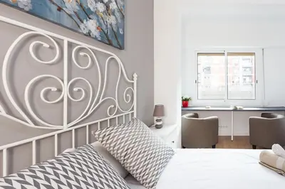 a bedroom with a white bed and a desk at Sagrada Familia Butterfly in Barcelona