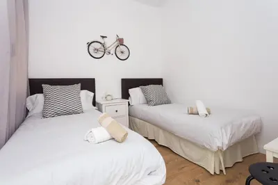two beds in a room with a bike on the wall at Sagrada Familia Butterfly in Barcelona