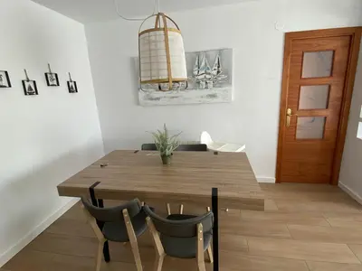a dining room with a wooden table and chairs at Vilamarlux VI in Vilassar de Mar