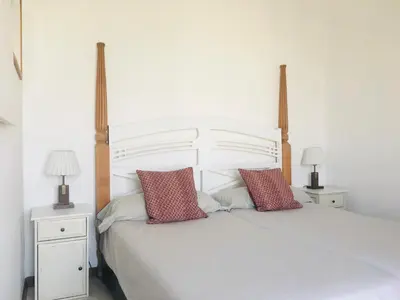 a white bed with two night stands and two lamps at Barceloneta Ramblas Apartments in Barcelona
