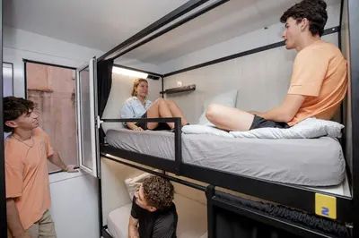 a group of people in a small room with bunk beds at Onefam Batlló in Barcelona