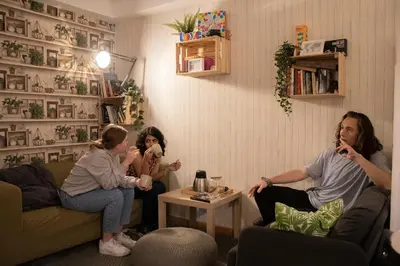 a group of people sitting in a living room playing a video game at Onefam Batlló in Barcelona