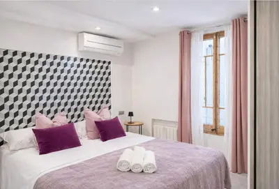 a bedroom with a large bed with purple pillows at Colom Apartment 3BR with Balcony & Port Vell Views in Barcelona