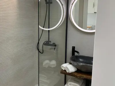 a bathroom with a shower with a sink and a mirror at Formentor in Castelldefels