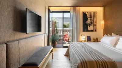 a bedroom with a bed and a tv and a balcony at Hotel Casa Sagnier in Barcelona