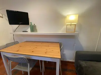 a room with a table with a tv and a lamp at 03 cozy barça 2,1 in Barcelona