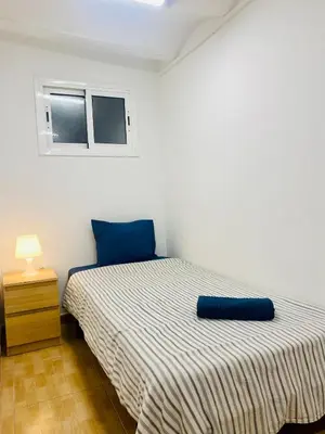 a bedroom with a bed with a blue pillow on it at 028 Apartament 2 2 in Barcelona