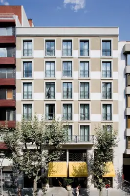 an apartment building with a yellow awning at Praktik Bakery in Barcelona