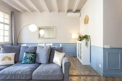 a living room with a blue couch with pillows at Apartamento Clsico Con Terraza in Barcelona