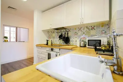 a kitchen with white cabinets and a white sink at Colorful With Cozy Terrace In Gracia in Barcelona