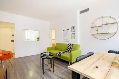 a living room with a green couch and a wooden table at Colorful With Cozy Terrace In Gracia in Barcelona
