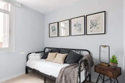 a bedroom with a black and white bed and a table at 2 Bdr Penthouse In Grcia in Barcelona