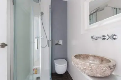 a bathroom with a stone sink and a toilet at 2 Bdr Penthouse In Grcia in Barcelona