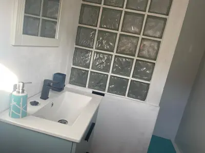 a bathroom with a sink and glass block windows at Raconet Azul - Circuito Cataluña in Vallromanas