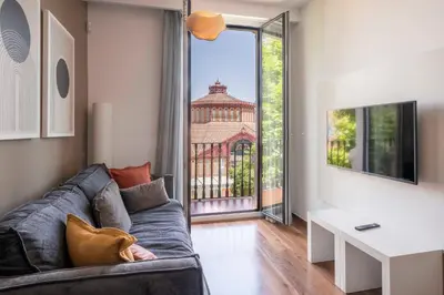 a living room with a couch and a large window at Aspasios Market Balconies Apartments in Barcelona