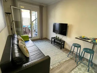 a living room with a leather couch and a flat screen tv at Sea Dreams with Amazing Terrace in Sitges
