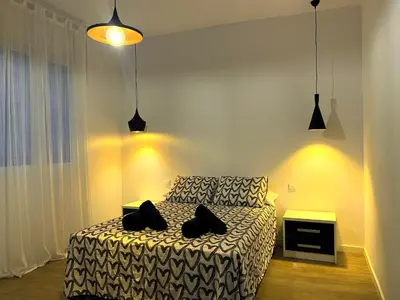 a bedroom with a bed with two black pillows on it at Casa adosada a 20 min centro de Barcelona in Hospitalet de Llobregat