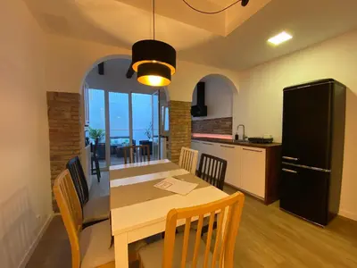 a kitchen and dining room with a table and a refrigerator at Casa adosada a 20 min centro de Barcelona in Hospitalet de Llobregat