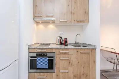 a kitchen with wooden cabinets and a stove at Magical Design With Terrace in Hospitalet de Llobregat