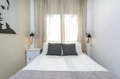a bedroom with a large white bed and a window at Magical Design With Terrace in Hospitalet de Llobregat