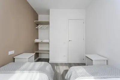two beds in a bedroom with white walls at Magical Design With Terrace in Hospitalet de Llobregat