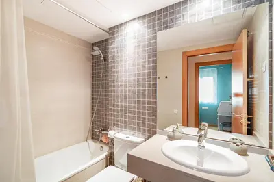a bathroom with a sink and a toilet and a mirror at FORUM BEACH 2 AND POOL APARTMENT BARCELONA in Sant Adria de Besos