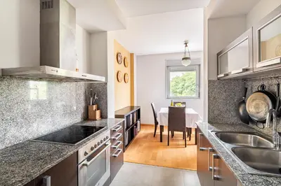 a kitchen with granite counter tops and a dining room at FORUM BEACH 2 AND POOL APARTMENT BARCELONA in Sant Adria de Besos