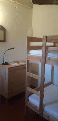 a bedroom with bunk beds and a desk with a lamp at Masia en plena naturaleza y tranquilidad in San Quintín de Mediona