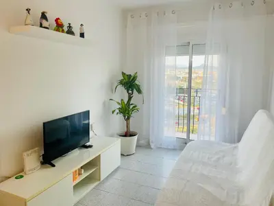 a white living room with a television and a couch at Barca 1 in Sant Adria de Besos