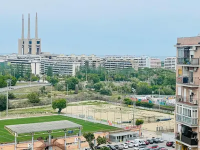 a tennis court in a city with a parking lot at Barca 1 in Sant Adria de Besos