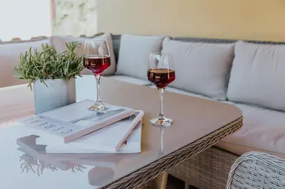 two glasses of wine on a table with a couch at Collbato Resort. in Collbató
