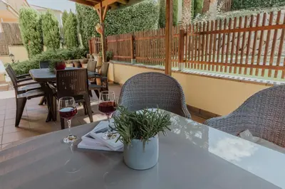 a table with two glasses of wine on a patio at Collbato Resort. in Collbató