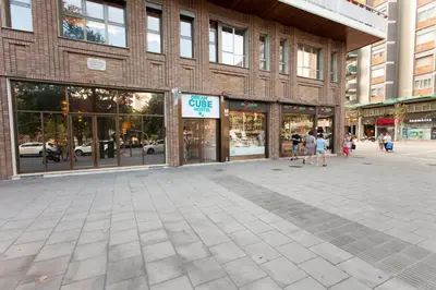 a street with people walking in front of a store at Dream Cube Hostel in Barcelona