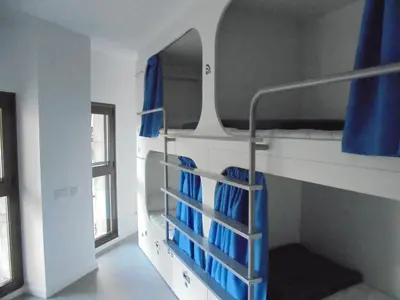 a room with a bunk bed with blue curtains at Dream Cube Hostel in Barcelona