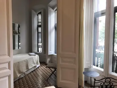 a hallway with a room with a bed and windows at Casa Consell Bailen, Guest House in Barcelona