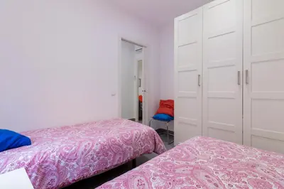 a bedroom with two beds and a closet at Bed&BCN Park Güell in Barcelona