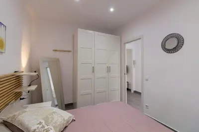 a white bedroom with a bed and a closet at Bed&BCN Park Güell in Barcelona